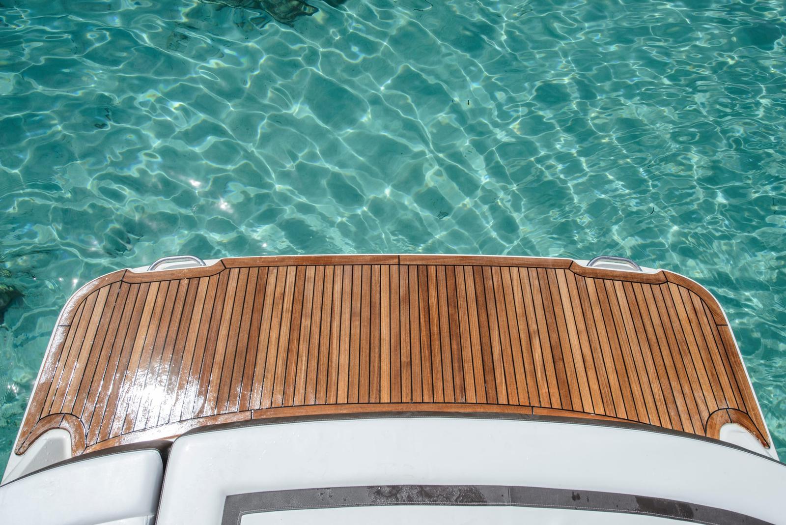 Teak swim platform detail over clear water